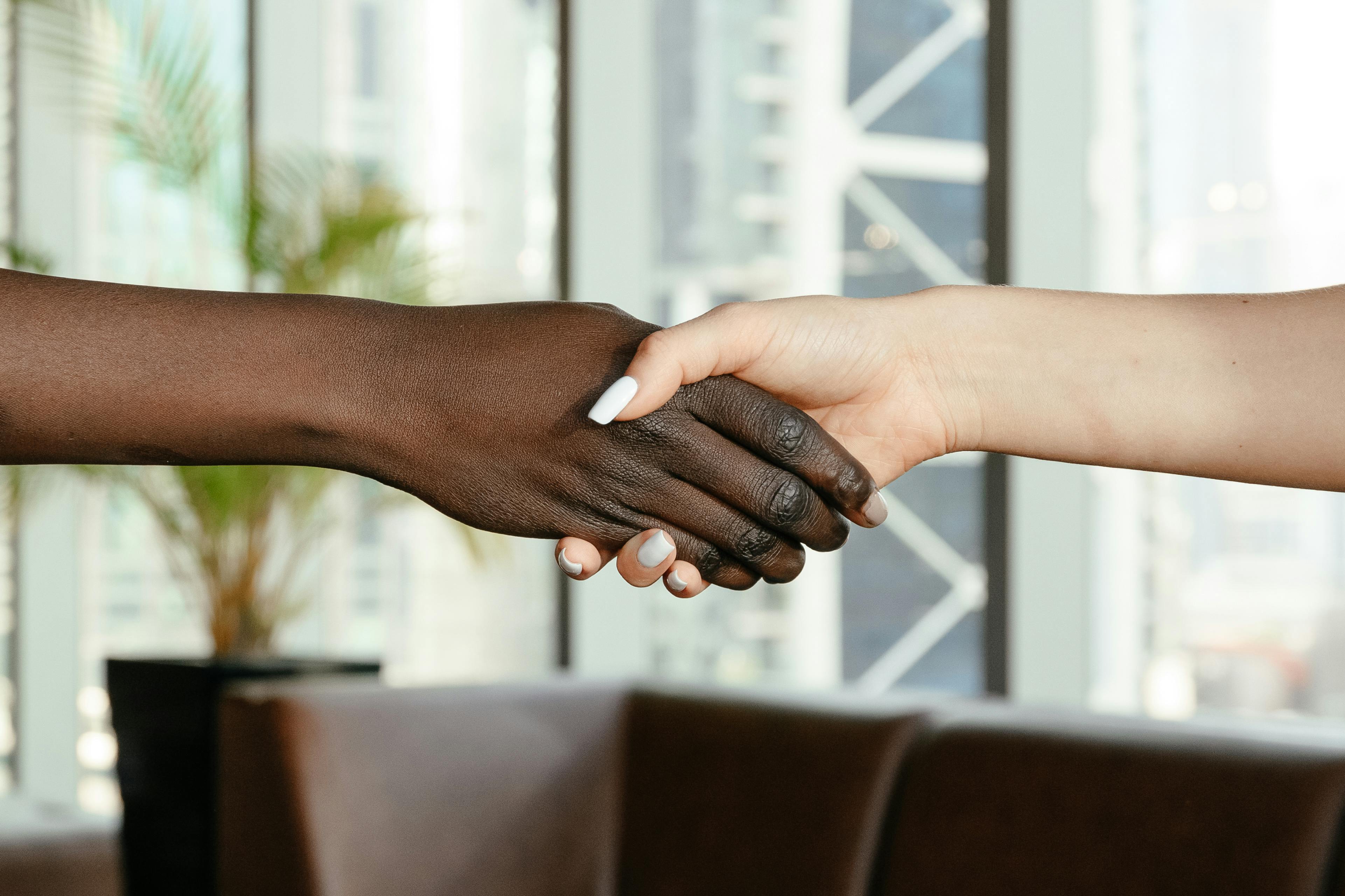 multiracial women shaking hands in modern office