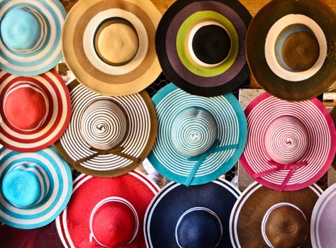 Vibrant straw hats arranged in a market display in Collioure, France.