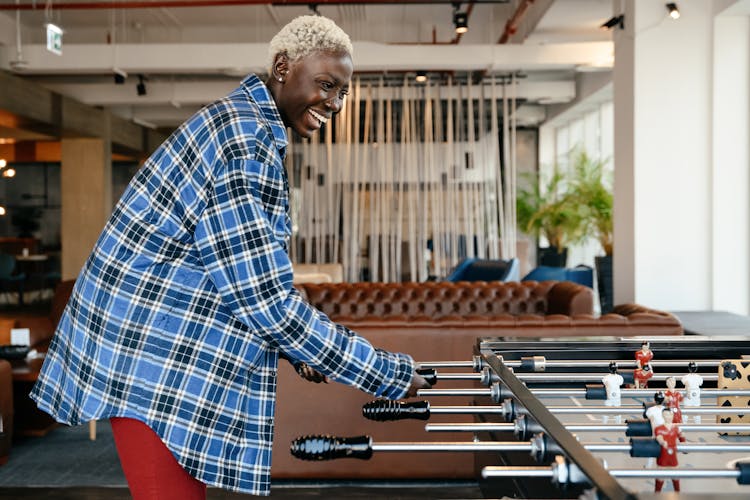 Happy Black Woman Playing Foosball At Home