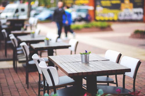 Street view of a coffee terrace with tables and chairs