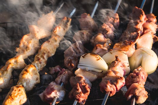 Close-up of juicy chicken and onion skewers grilling outdoors in Lebanon.