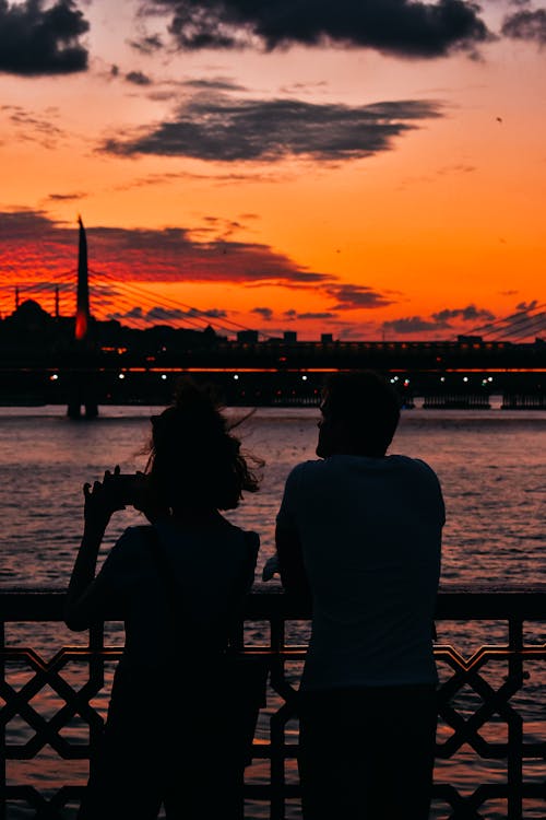 A Silhouette of a Man and a Woman Standing Near a Sea