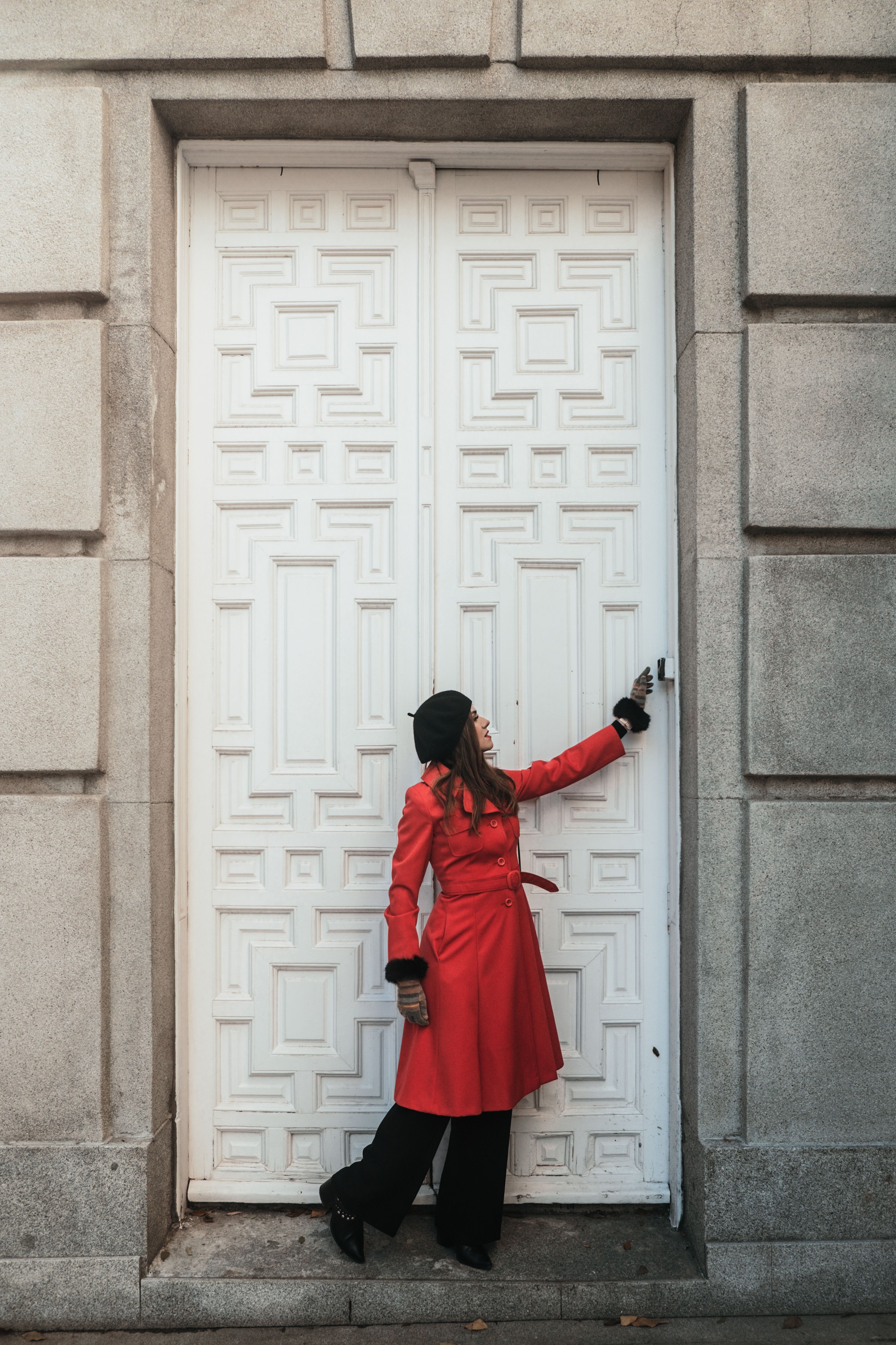 A Woman in Red Trench Coat Standing in Front of a White Door · Free ...
