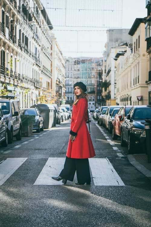 A Woman in Red Coat Crossing on Pedestrian Lane