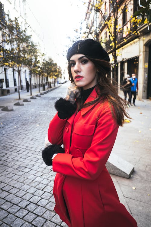 Woman in Black Beret Hat and Red Coat Standing on the Street