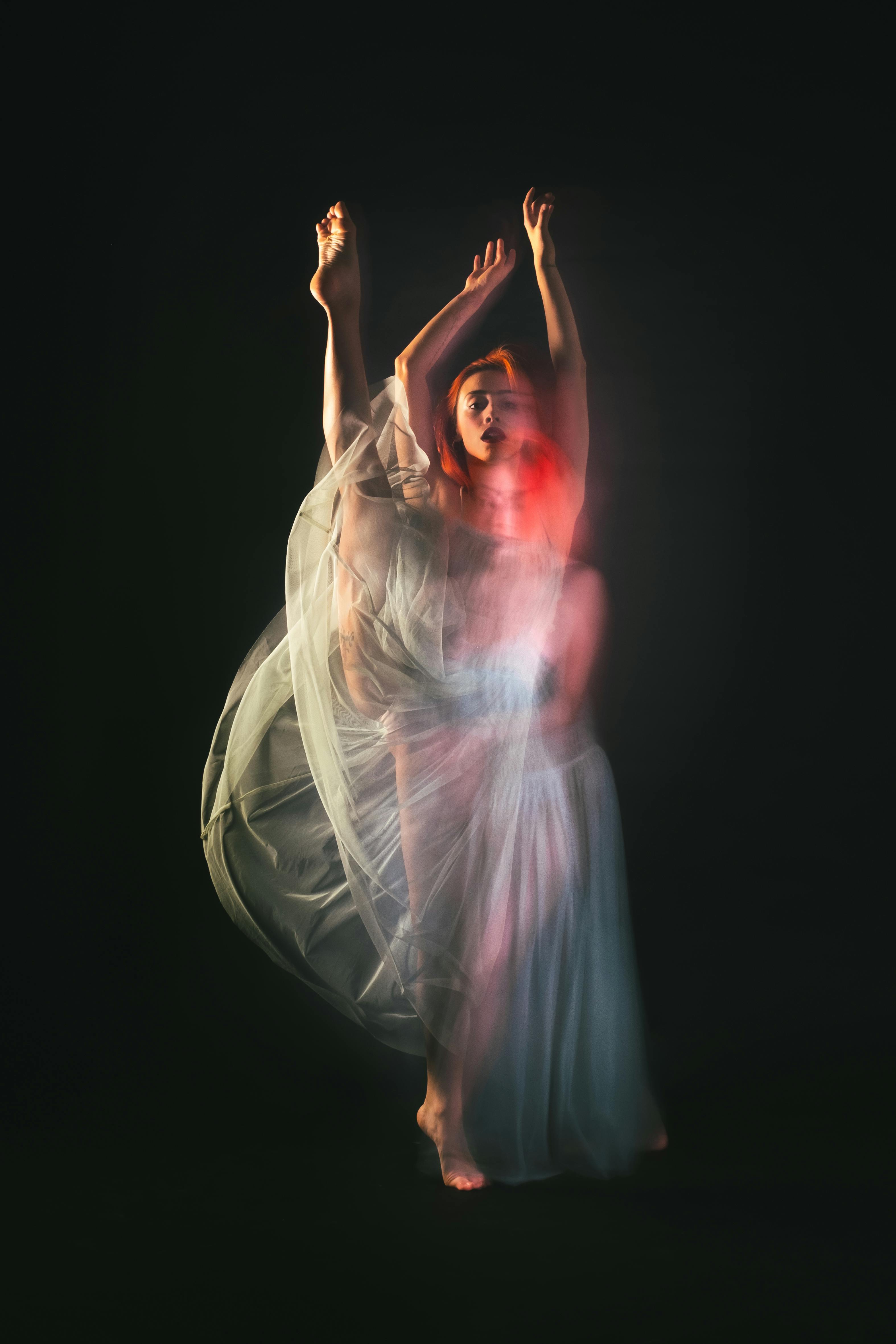 Free Artistic capture of a female dancer in motion with a graceful flowing dress using long exposure. Stock Photo
