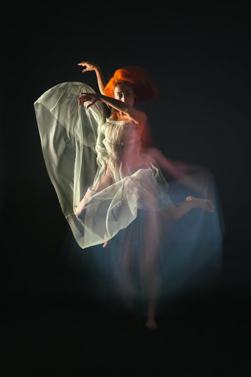 A Woman in White Dress Dancing Gracefully