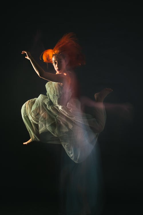 A Woman in White Dress Dancing Gracefully