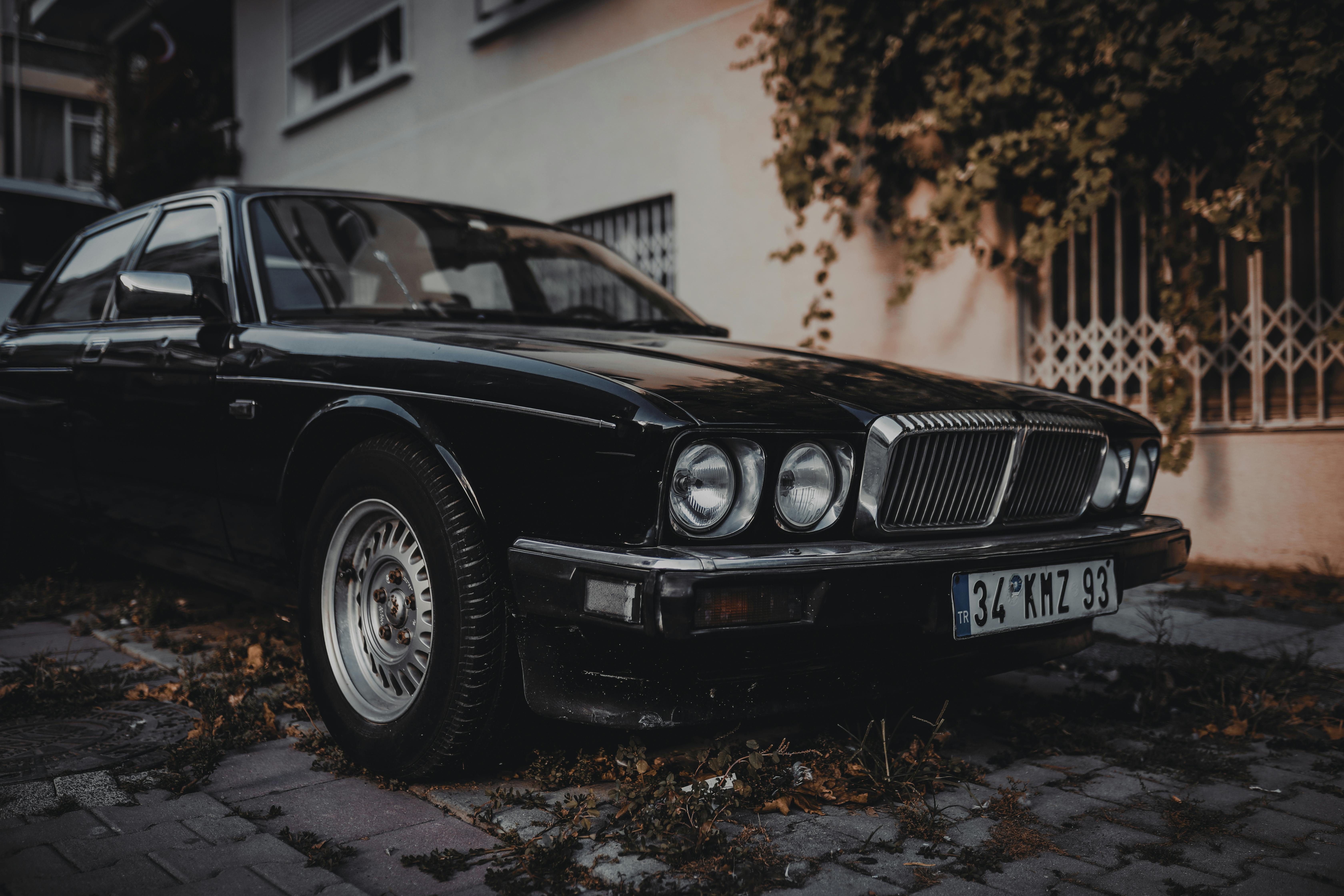 Greyscale Photo of Vintage Car Parked Beside Building · Free Stock Photo