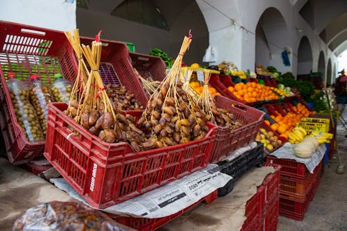 Free Stall of tasty heap of dates placed in box near various ripe fruits in local bazaar on street in city Stock Photo