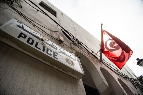 Free From below exterior of concrete house with arched elements and Police signboard and hanging flag of Turkey located on street in city Stock Photo