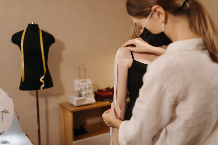 A Seamstress Measuring Her Client's Arm