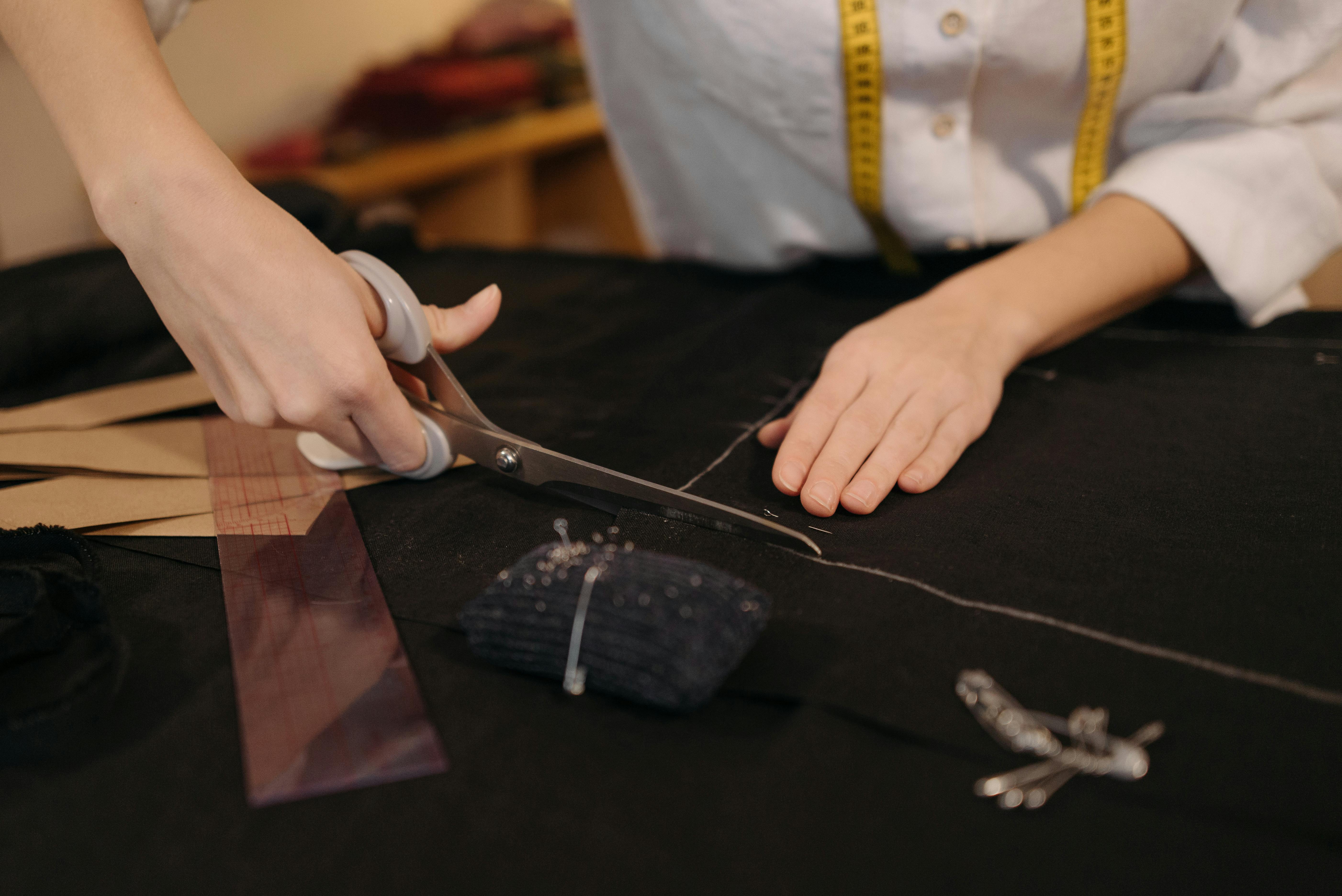 a person holding silver scissor