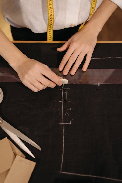Person Putting Markings on a Black Fabric