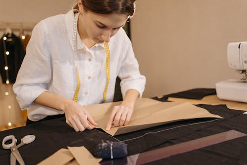 Woman Putting a Pattern on a Black Fabric