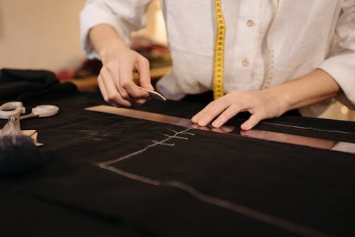 Person Putting Markings on a Black Fabric