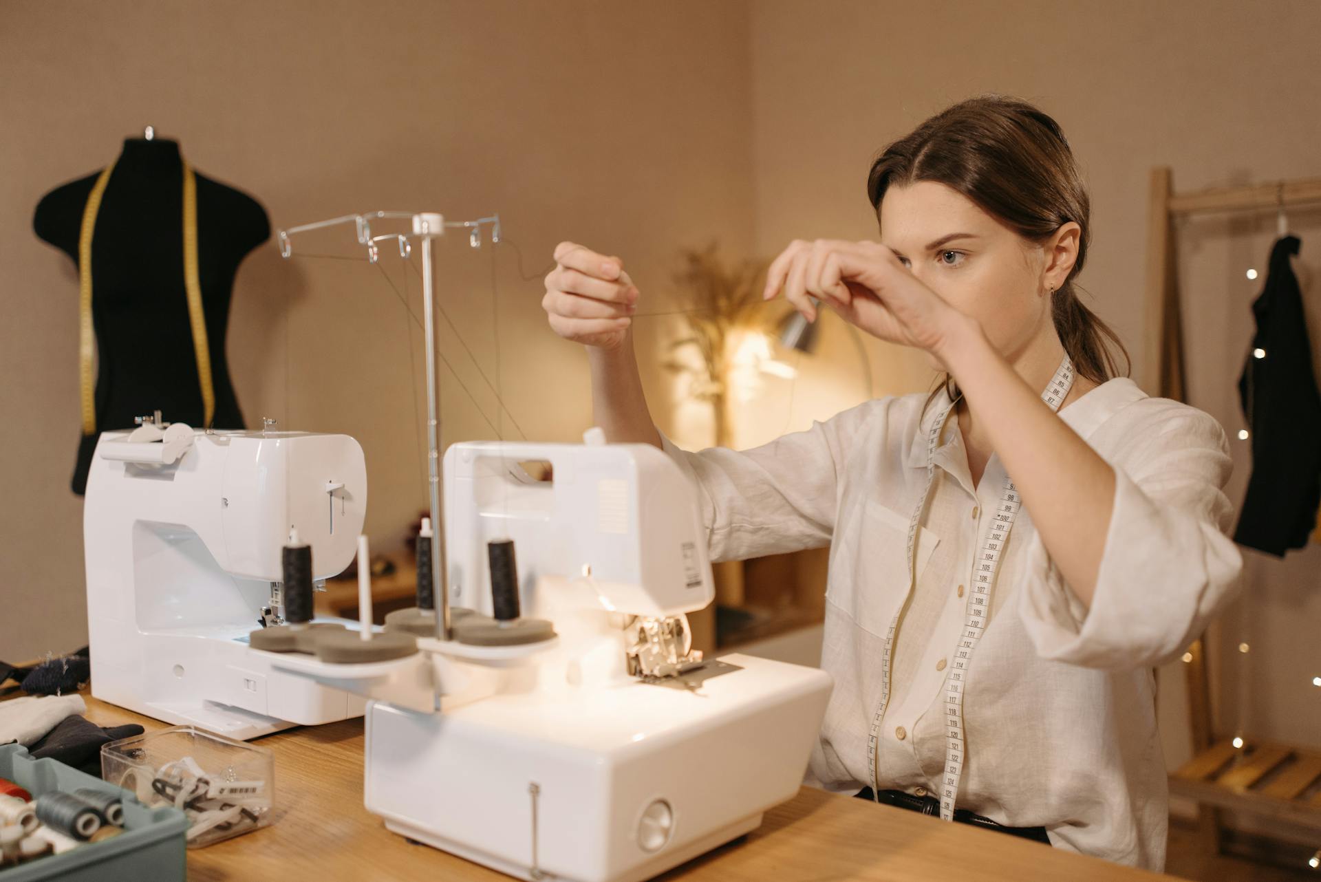 Woman sewing with a machine, focused on tailoring and small business setup.