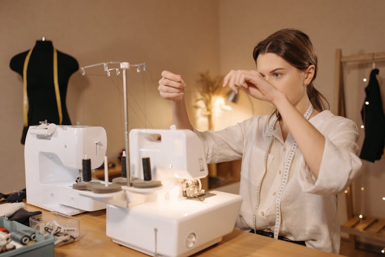 Woman Fixing A Sewing Machine