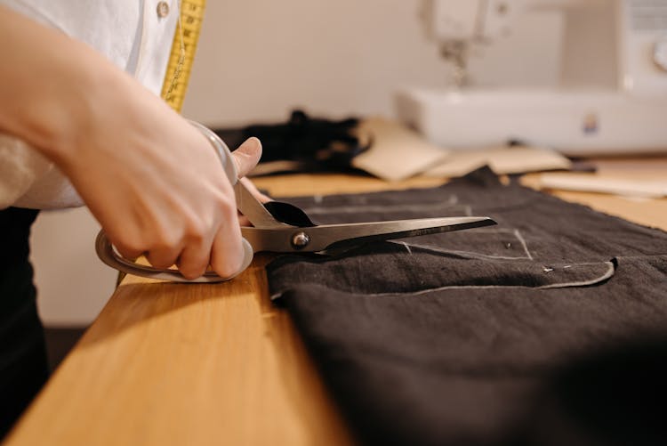 Tailor Cutting A Black Fabric