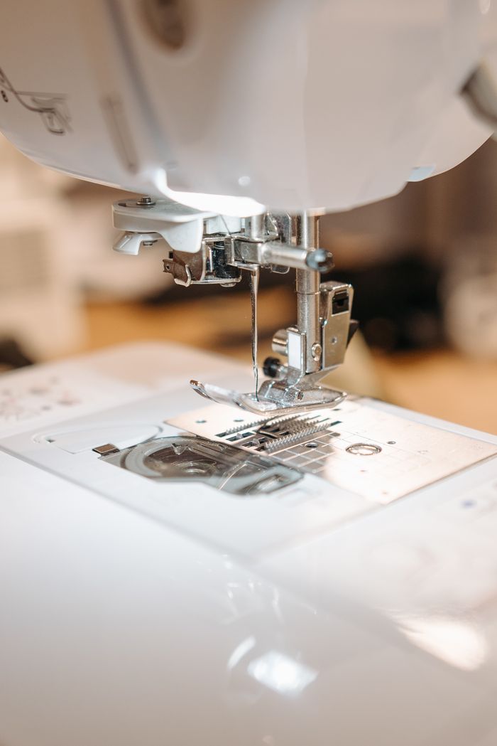 Close up of a sewing machine needle stitching fabric