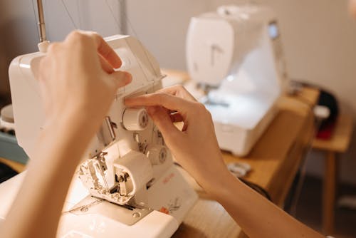 Free Hands Inserting Thread on Sewing Machine Stock Photo