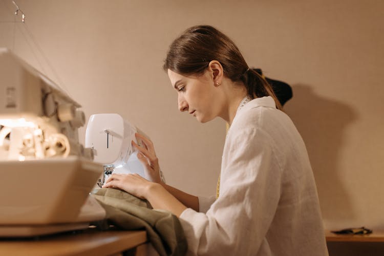 Woman Sewing Textile On Sewing Machine