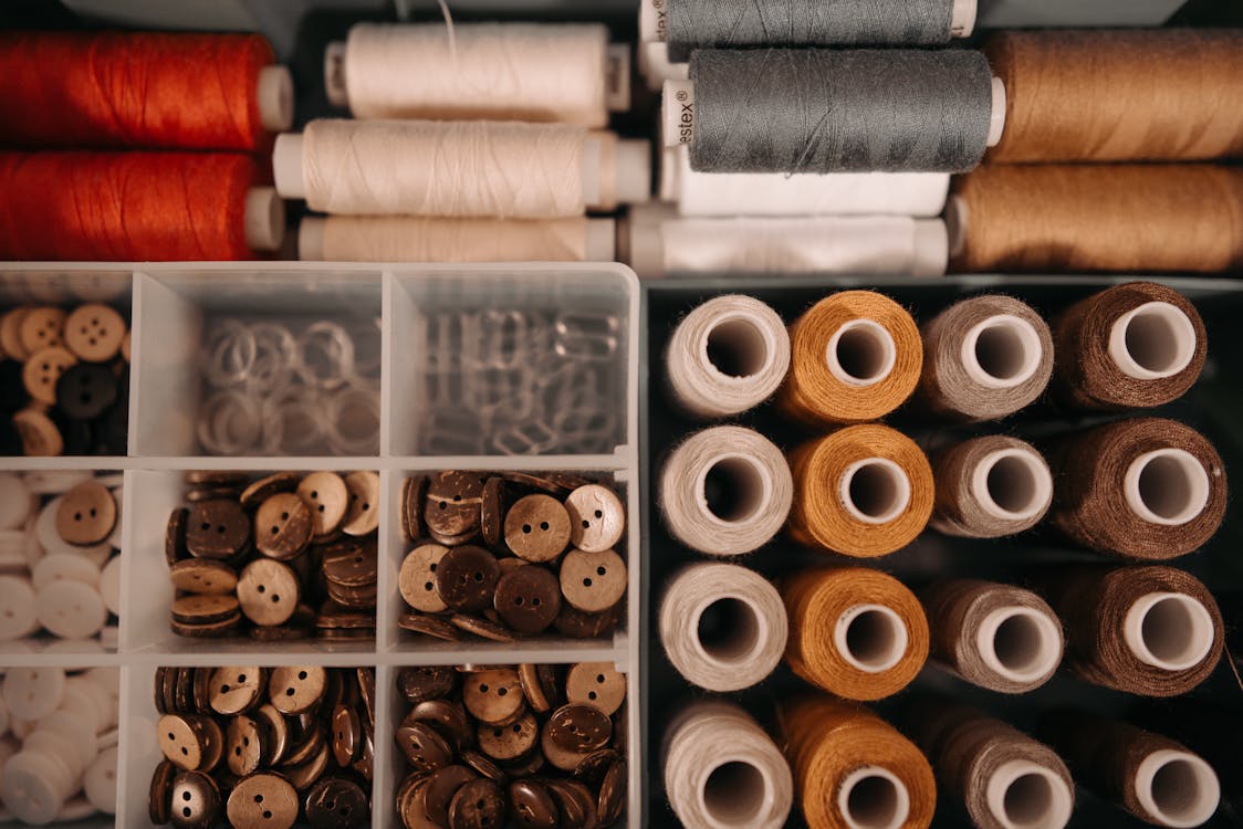 Free Variety of Sewing Threads and Buttons in a Box with Divider Stock Photo