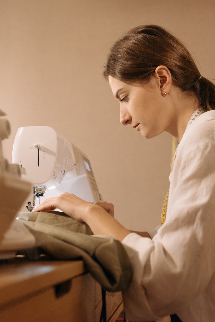 A Woman Using A Sewing Machine 