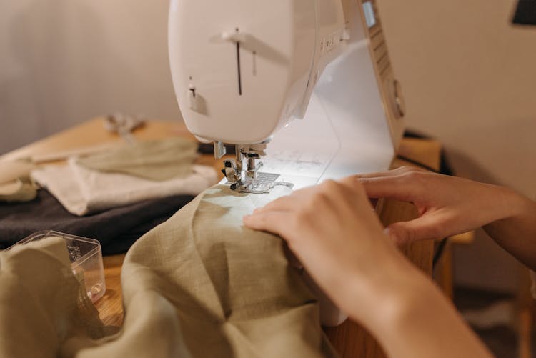 Person Sewing Cloth On A Sewing Machine