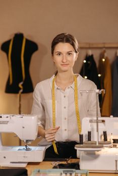 A skilled seamstress surrounded by sewing machines and tools in a fashion design studio.