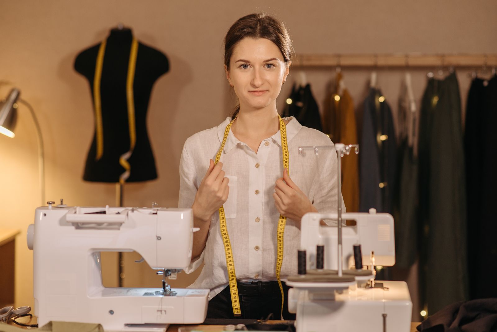 Woman working at a sewing machine stitching cotton fabric
