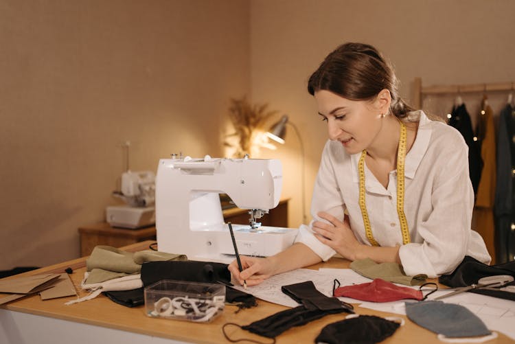 A Woman Drawing A Pattern On A White Paper