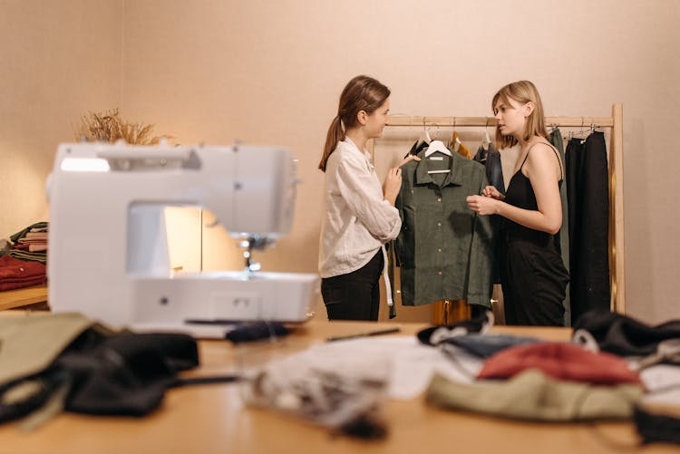 Fashion Designer Showing New Long Sleeve Polo Shirt To A Customer In Black Tank Top