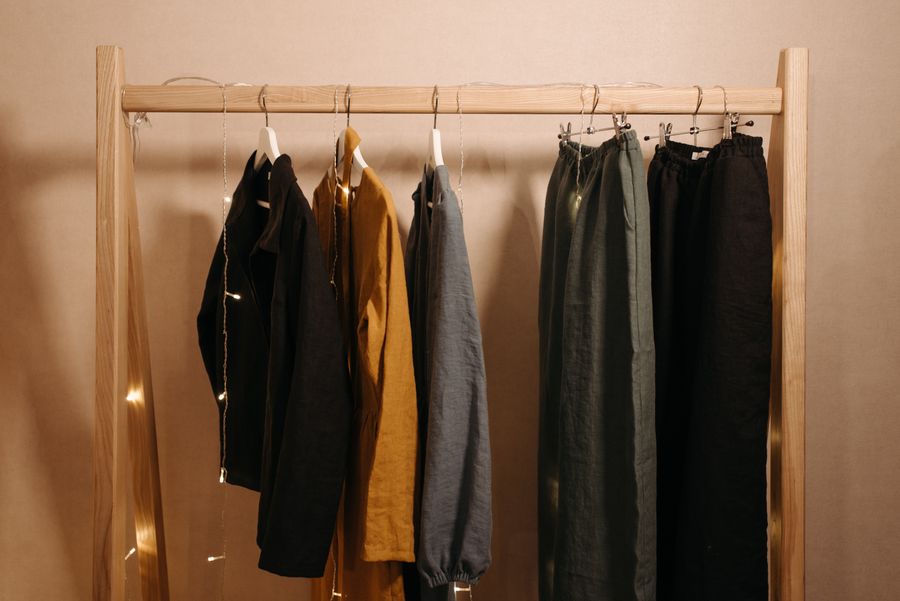 New-season pieces on a wooden rail in warm daylight