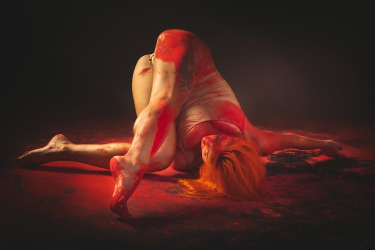 A Woman Lying In The Floor With Red Paint On Her Body