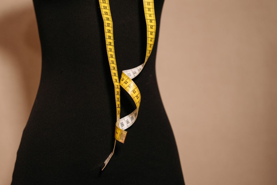 Elegant black mannequin with yellow measuring tape, perfect for fashion design themes. - The Importance of Understanding Return Policies