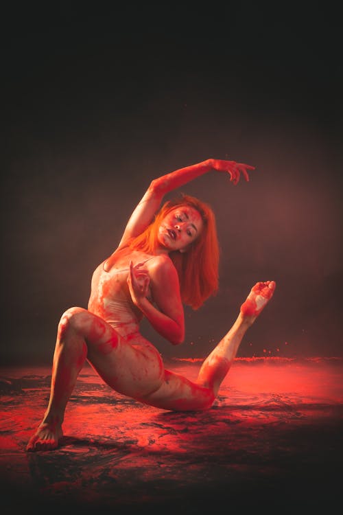 A Flexible Woman Covered in Red Powder