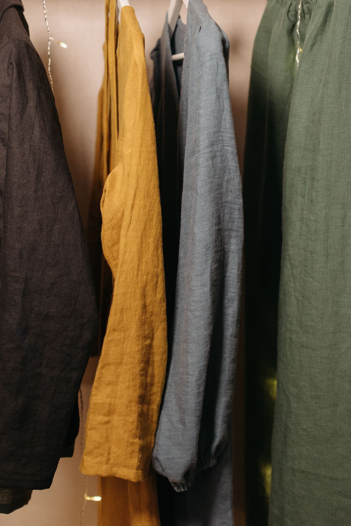 Natural-fibre clothing hung in a pale open wardrobe