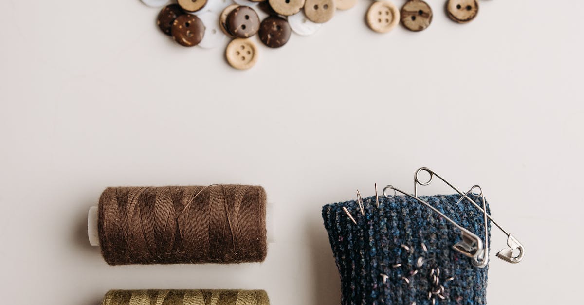 Stylish flat lay showcasing sewing threads, assorted buttons, and a pin cushion, perfect for crafting projects.