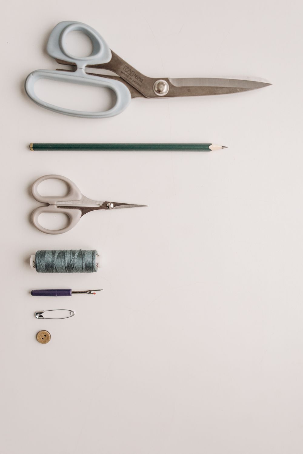 Soft measuring tape and sewing tools arranged on neutral fabric