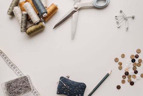 Sewing Threads Beside the Silver Scissors