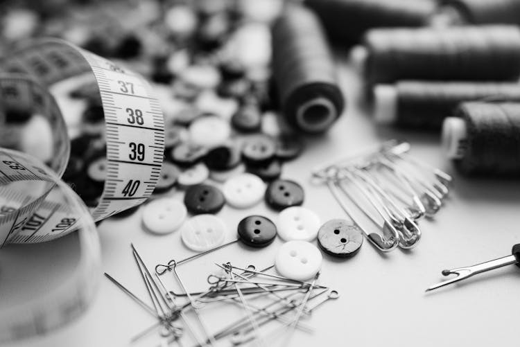 Grayscale Photography Of Threads And Needles On Table