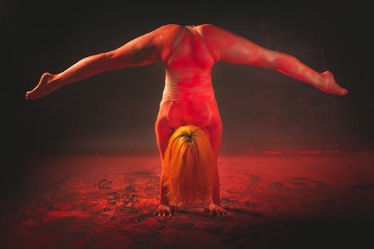 Dynamic handstand performer with vibrant powder effect on stage.