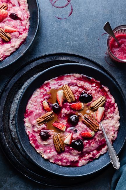 Delicious breakfast oatmeal with strawberries, cherries, and pecans in a vibrant setting.