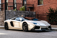 White and Blue Lamborghini Aventador Parked Beside Brown Brick Wall