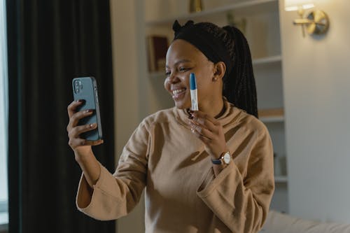 A Woman Showing a Pregnancy Test in a Video Call