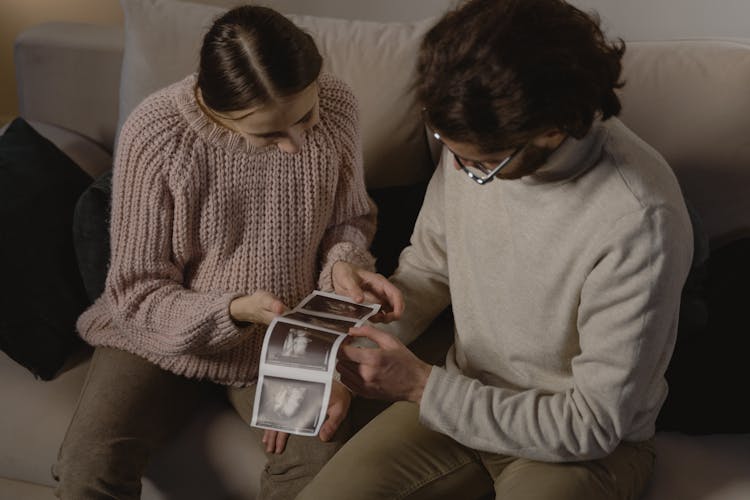 A Man And Woman Holding Ultrasound Images