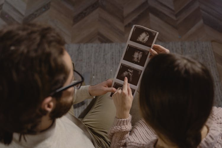 A Couple Looking At Sonogram Photos