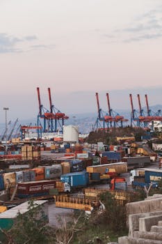 Industrial scene of Beirut port with colorful cargo containers and cranes during sunset.