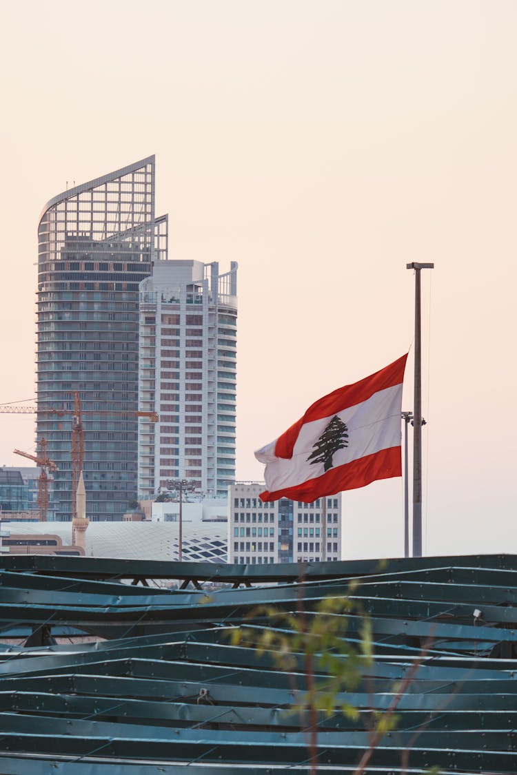 The Lebanese Flag On Pole With The Marina Tower In Beirut, Lebanon On Background